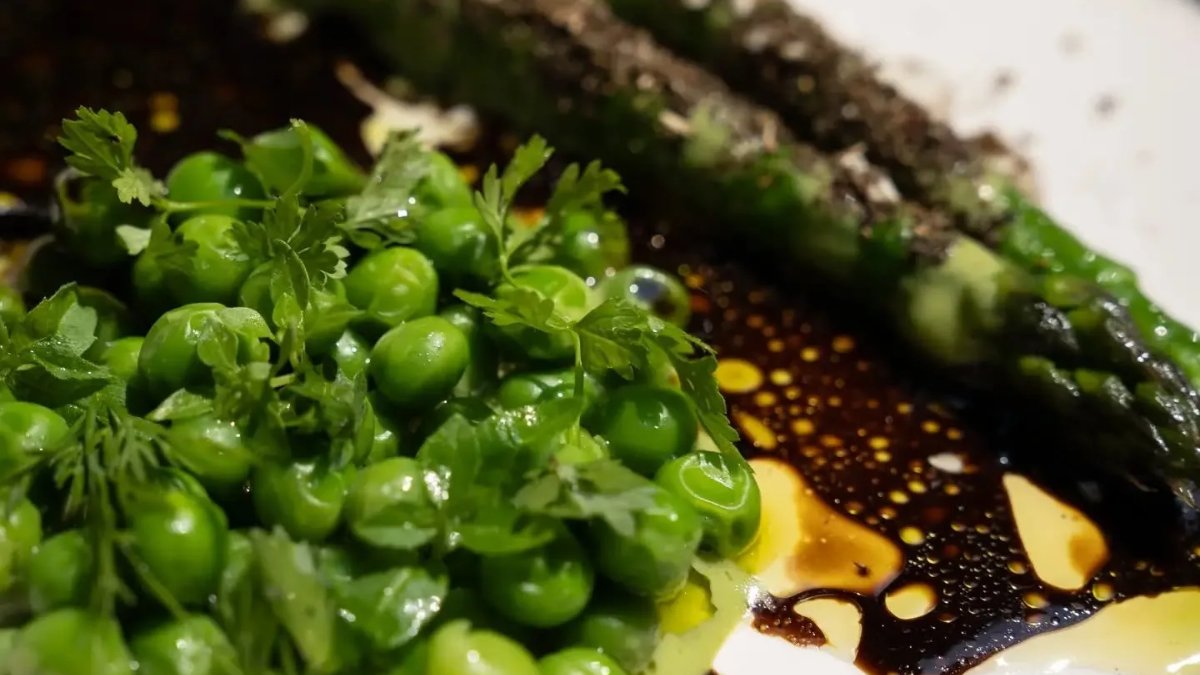 Un plat de petits pois frais et d’asperges vertes, relevé d’herbes et d’un jus brun, chez Accentué, restaurant à Lyon Un plat de petits pois frais et d’asperges vertes, relevé d’herbes et d’un jus brun, chez Accentué, restaurant à Lyon