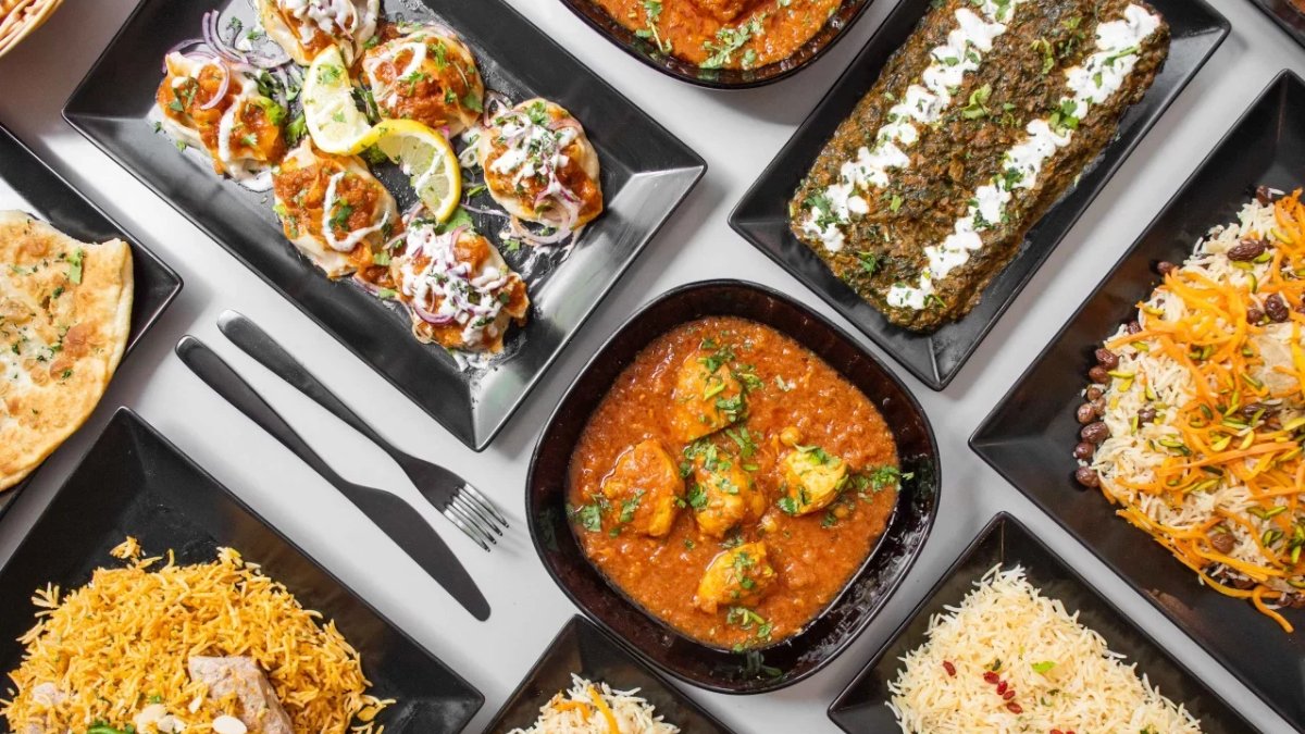 Une table de plats afghans chez Afghan Kitchen à Lyon : riz, curry, samoussas et pains