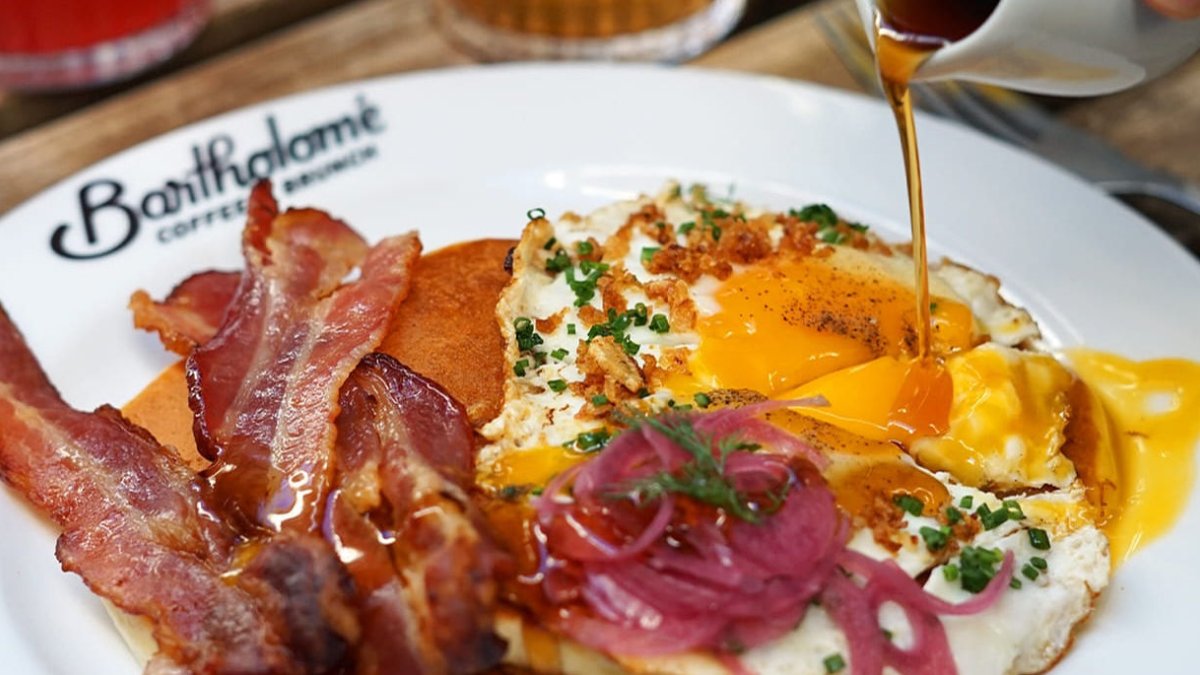Assiette de brunch chez Bartholomé à Lyon : œufs, bacon et oignons rouges marinés