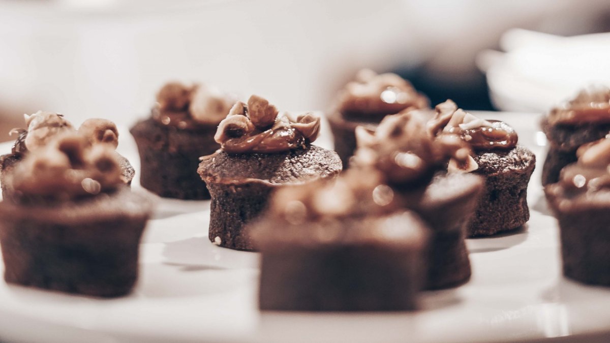 Des petits gâteaux au chocolat nappés de crème noisette sur une assiette blanche chez Bichon, auberge à Lyon
