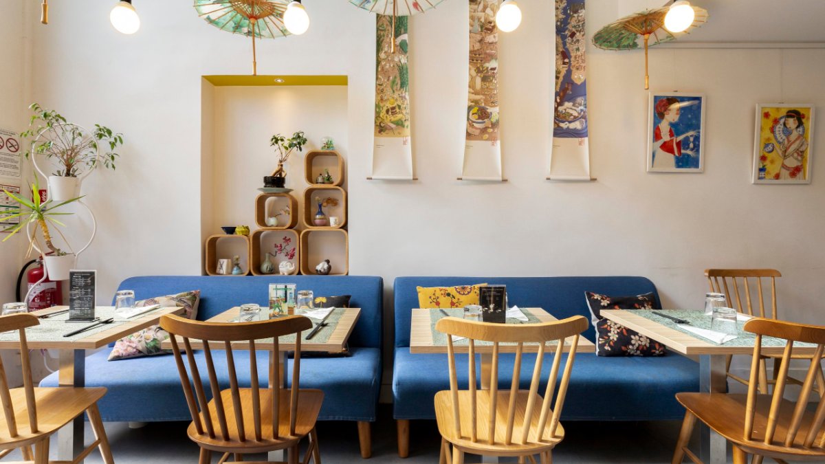 La salle du Bistro Zakka à Lyon : banquette bleue, chaises en bois et ombrelles chinoises La salle du Bistro Zakka à Lyon : banquette bleue, chaises en bois et ombrelles chinoises