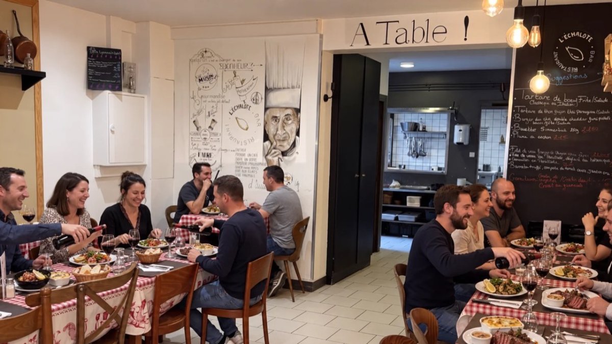 Des convives attablés dans la salle conviviale de la brasserie L’Échalote à Lyon, autour de plats lyonnais