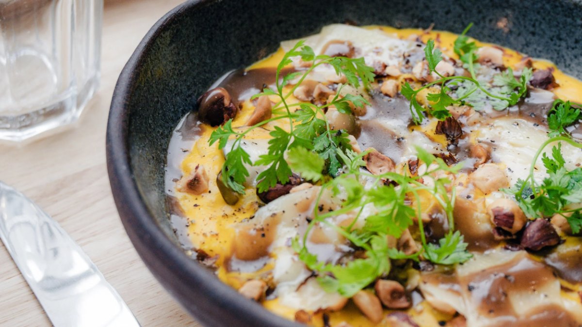 Une omelette garnie d’herbes fraîches et de noisettes dans un bol noir, servie au Café Noon à Lyon Une omelette garnie d’herbes fraîches et de noisettes dans un bol noir, servie au Café Noon à Lyon