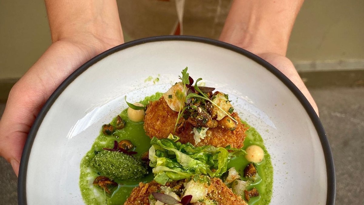 Une assiette du restaurant Canaima à Lyon, croquettes dorées sur un velouté vert Une assiette du restaurant Canaima à Lyon, croquettes dorées sur un velouté vert
