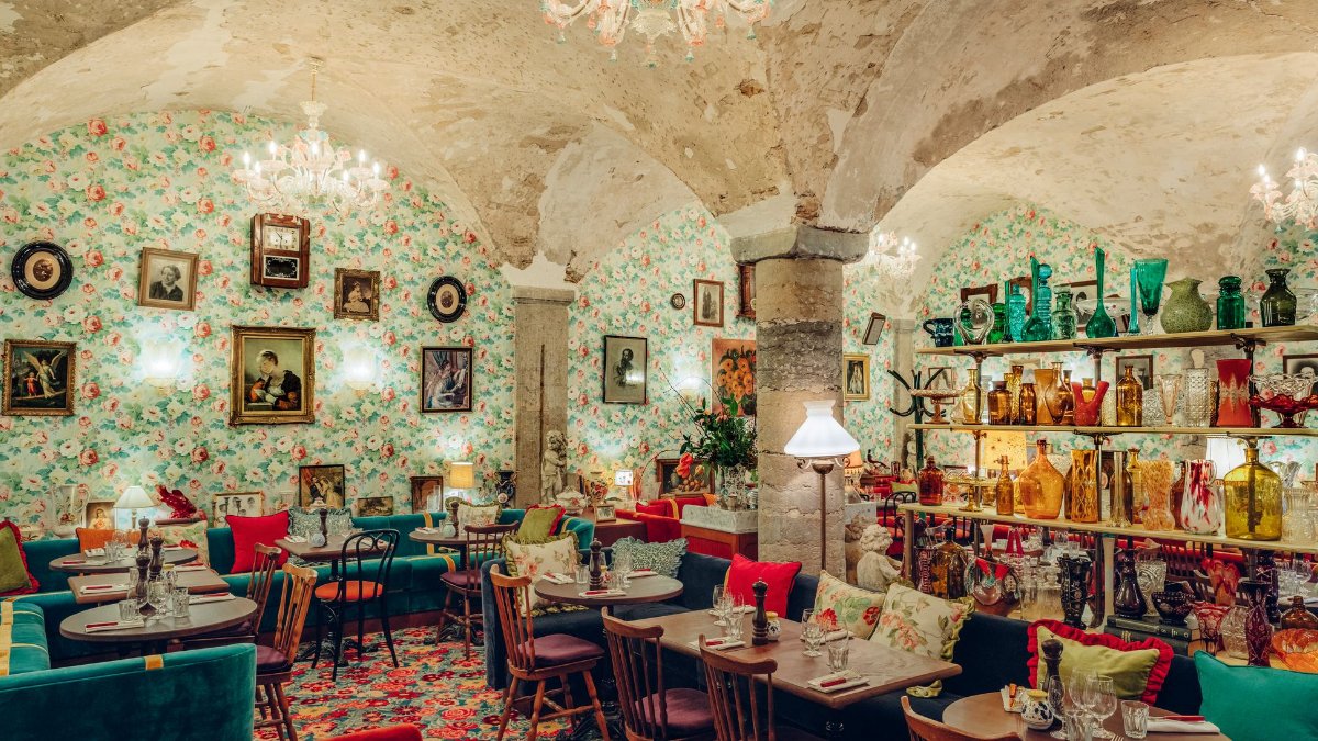 La salle voûtée de Carmelo à Lyon, avec ses tapisseries fleuries, ses banquettes colorées et sa collection de verreries La salle voûtée de Carmelo à Lyon, avec ses tapisseries fleuries, ses banquettes colorées et sa collection de verreries