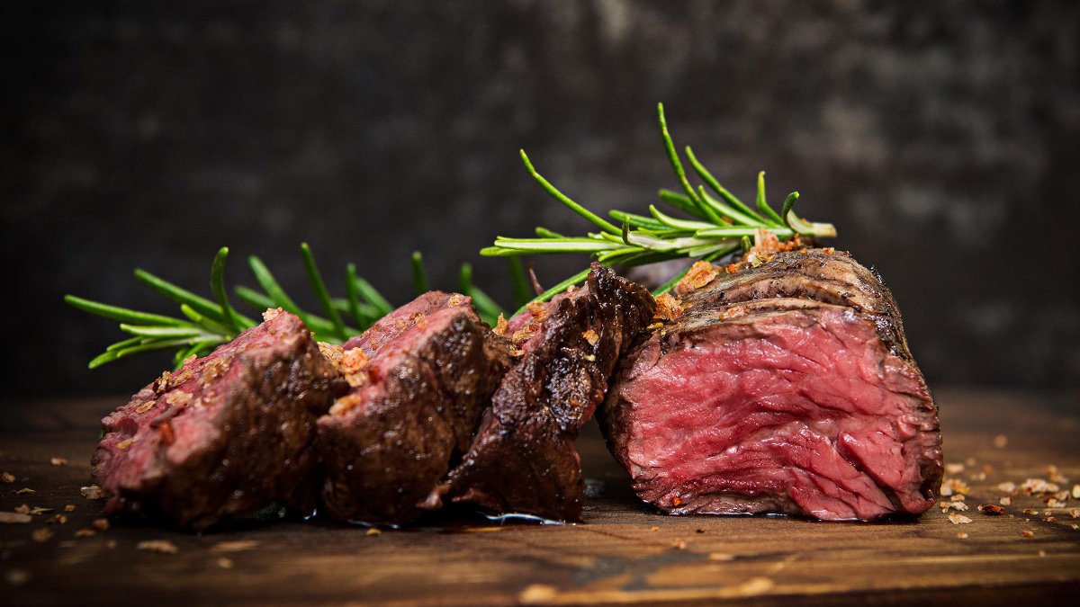 Un pavé de bœuf saignant aux brins de romarin sur une planche en bois, spécialité de la boucherie-restaurant Carnegie Hall à Lyon Un pavé de bœuf saignant aux brins de romarin sur une planche en bois, spécialité de la boucherie-restaurant Carnegie Hall à Lyon