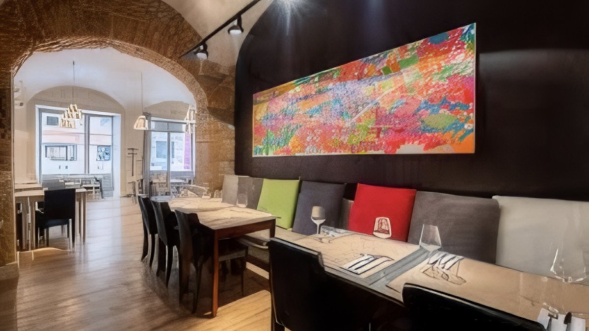 La salle du restaurant Carré Royal à Lyon, avec ses voûtes en pierre, sa banquette en cuir et son grand tableau coloré La salle du restaurant Carré Royal à Lyon, avec ses voûtes en pierre, sa banquette en cuir et son grand tableau coloré