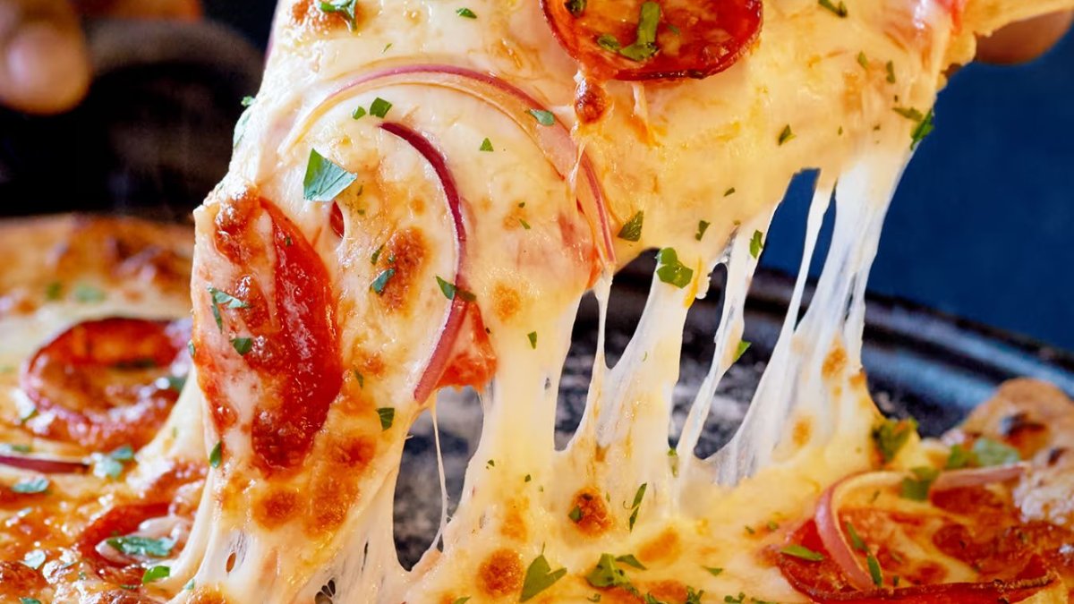 Une part de pizza au salami et aux oignons rouges, avec son fromage filant, chez Viko, pizzeria artisanale à Lyon