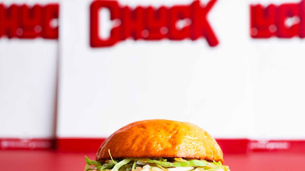 Un cheeseburger devant l’enseigne rouge de Chuck, burger joint à Lyon Un cheeseburger devant l’enseigne rouge de Chuck, burger joint à Lyon