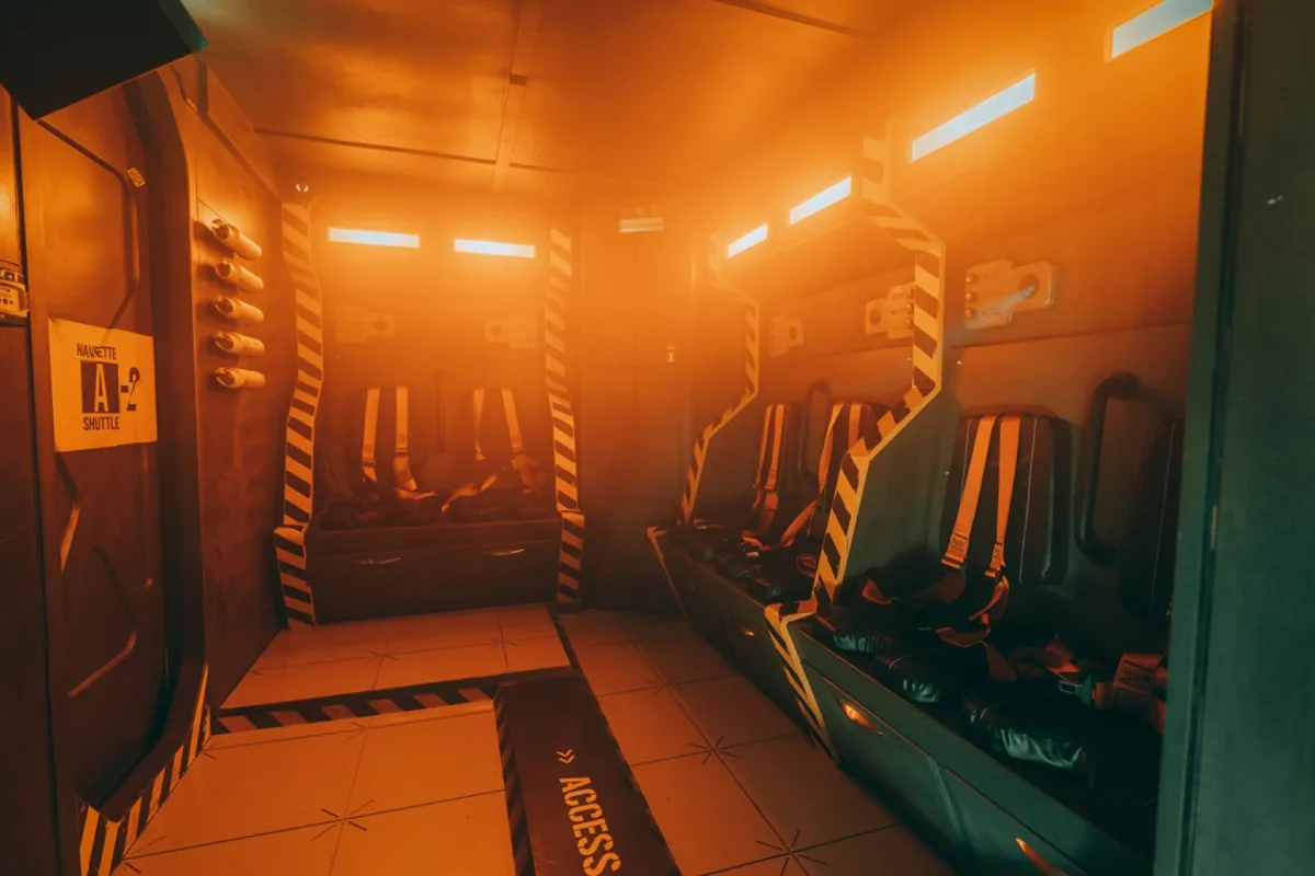 Couloir du vaisseau spatial baigné de lumière orange dans la salle Alien de l’escape game Clap Escape à Lyon 6e