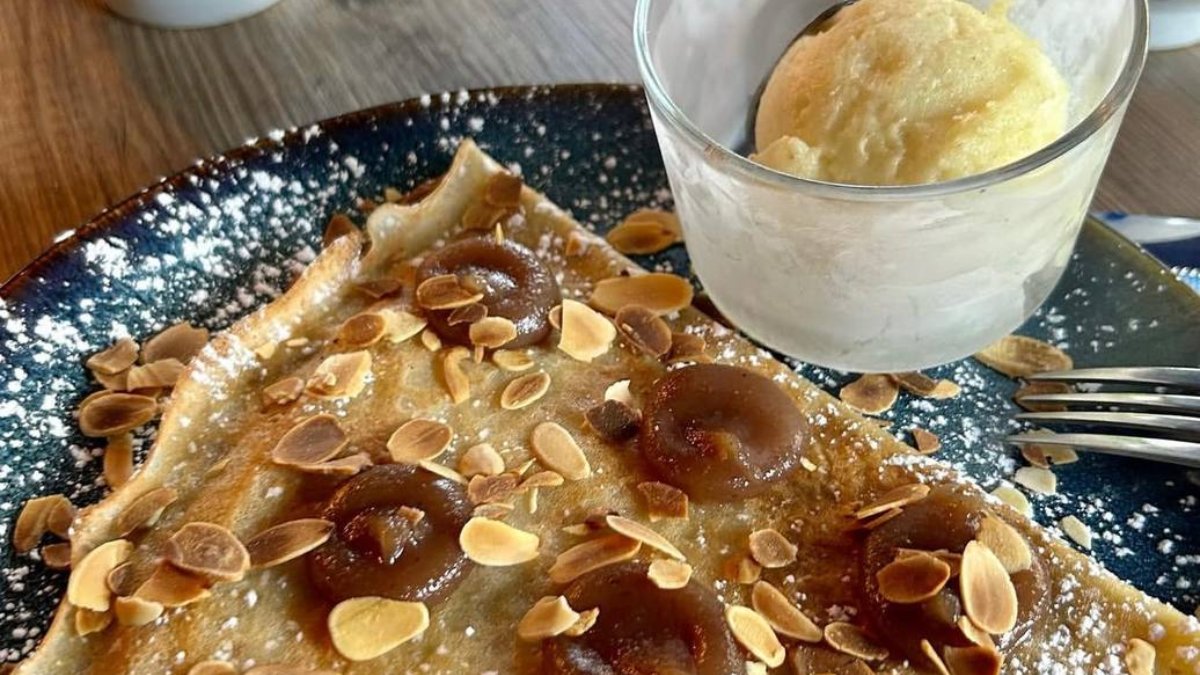Une crêpe sucrée aux amandes effilées et à la sauce chocolat, accompagnée d’une boule de glace vanille, à la Crêperie Bigoudène à Lyon