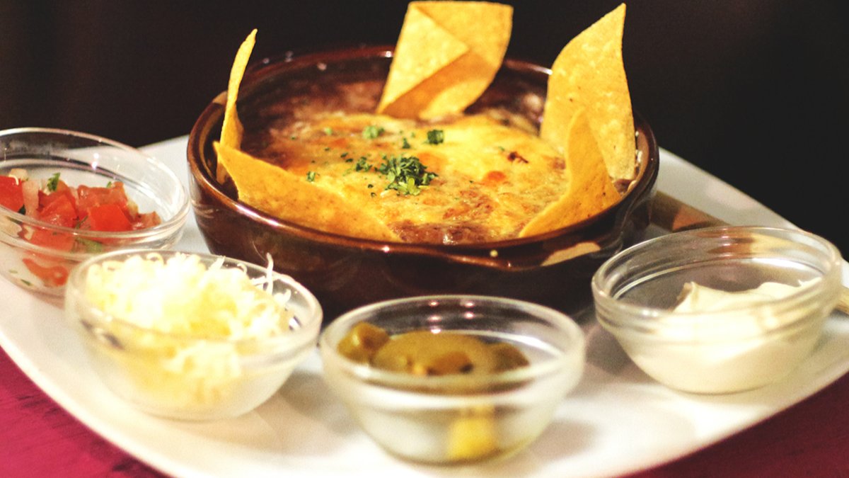 Un chili con queso gratiné et ses tortillas, avec ses petits bols de garnitures, chez El Sombrero à Lyon