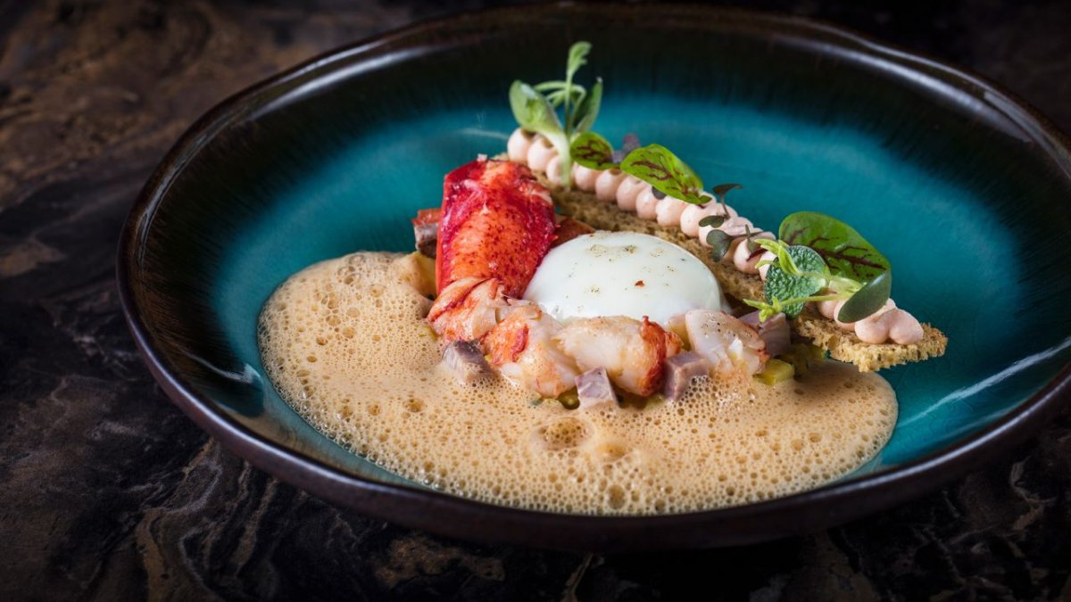 Un plat de homard et mousse onctueuse servi dans une assiette bleu profond à La Table 101, restaurant semi-gastronomique à Lyon Part-Dieu Un plat de homard et mousse onctueuse servi dans une assiette bleu profond à La Table 101, restaurant semi-gastronomique à Lyon Part-Dieu