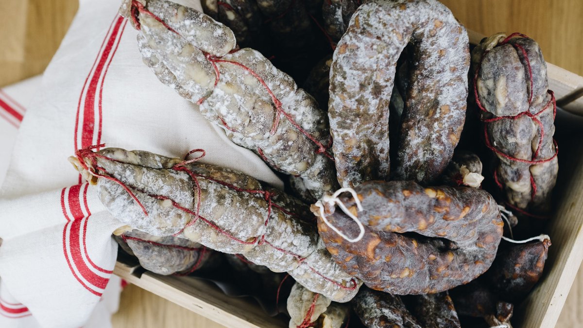 Saucissons secs sur un torchon rayé de rouge, une spécialité de L’Amour de Nuit à Lyon