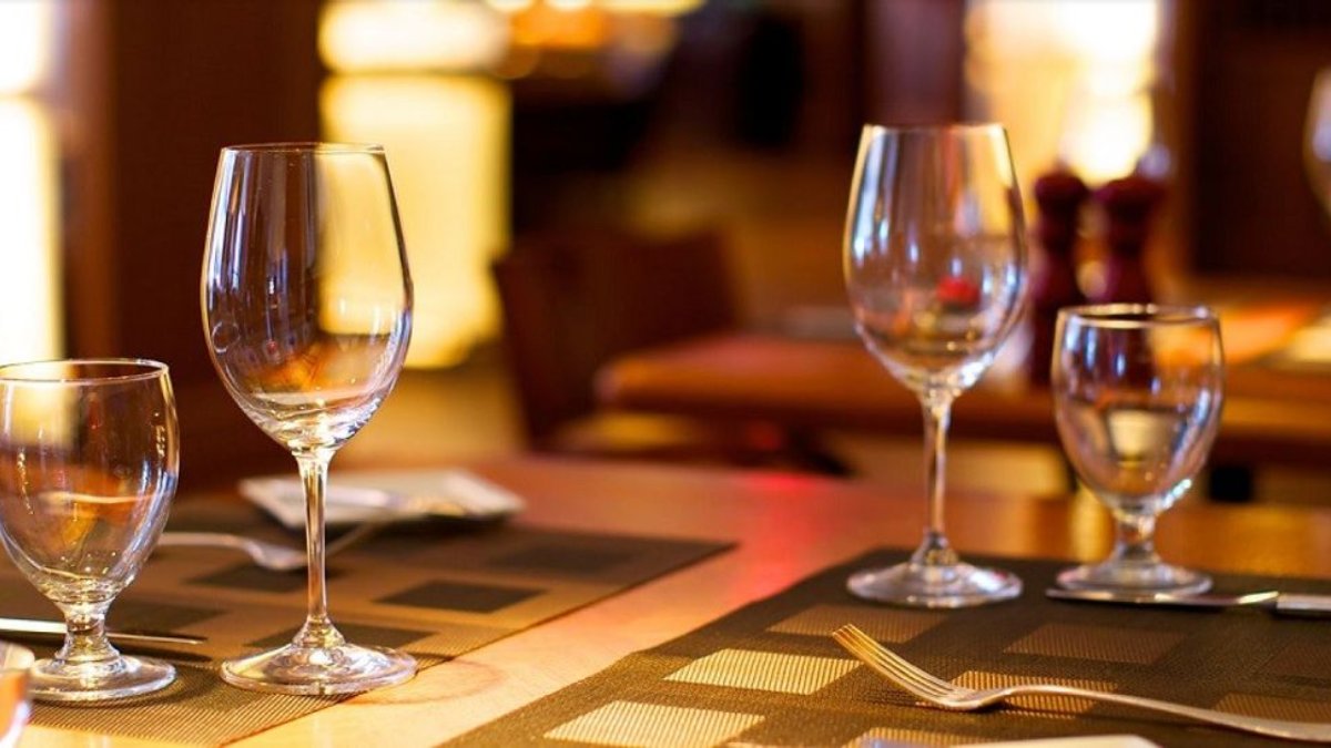 Une table dressée avec verres à pied et couverts dans la salle du restaurant Le Plato, bistronomie à Lyon