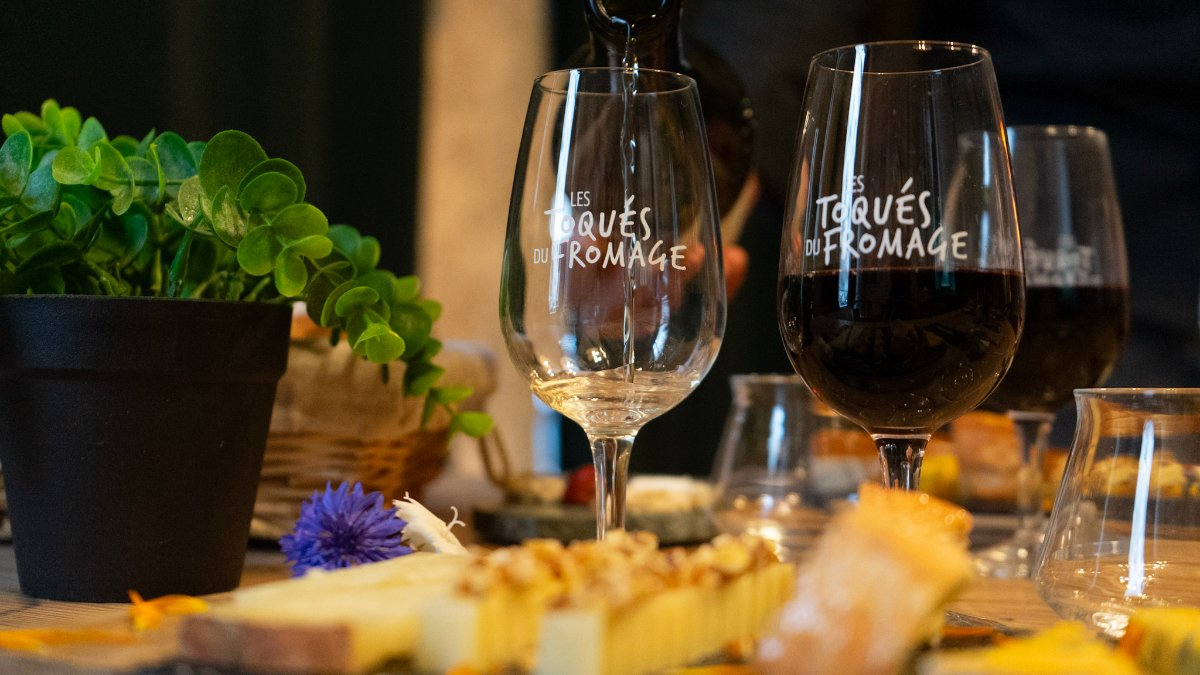 Des verres de vin blanc et de vin rouge devant un plateau de fromages, chez Les Toqués du fromage à Lyon Des verres de vin blanc et de vin rouge devant un plateau de fromages, chez Les Toqués du fromage à Lyon
