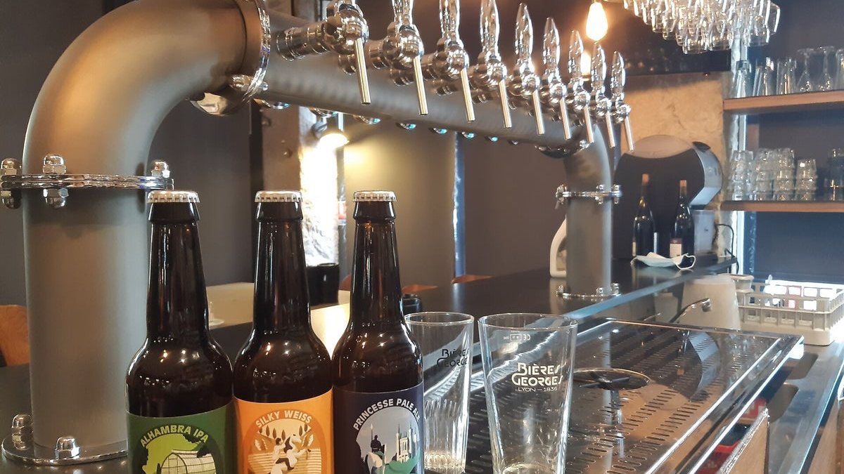 Trois bières artisanales en bouteille devant les tireuses du bar de LOKACE à Lyon Trois bières artisanales en bouteille devant les tireuses du bar de LOKACE à Lyon