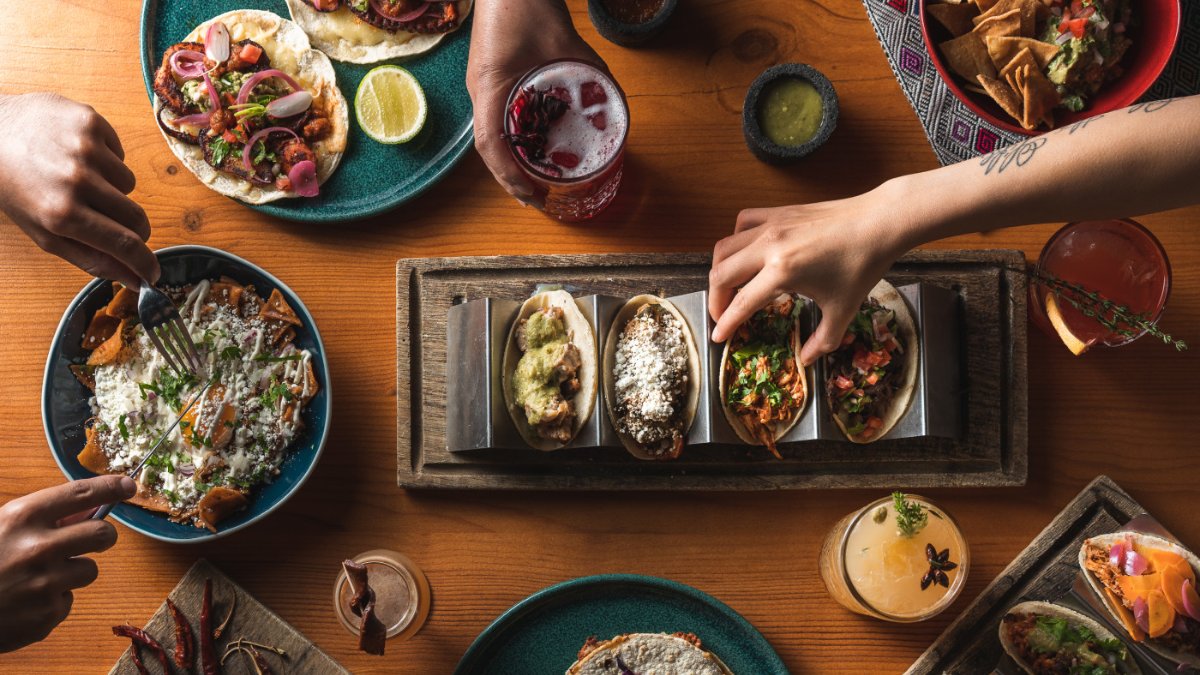 Une table de tacos, tostadas et cocktails vue du dessus, partagée entre convives au restaurant mexicain Piquín à Lyon Une table de tacos, tostadas et cocktails vue du dessus, partagée entre convives au restaurant mexicain Piquín à Lyon