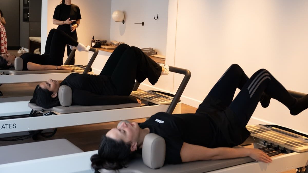 Des élèves allongées sur des reformers dans le studio clair de The Routine Pilates à Lyon Des élèves allongées sur des reformers dans le studio clair de The Routine Pilates à Lyon